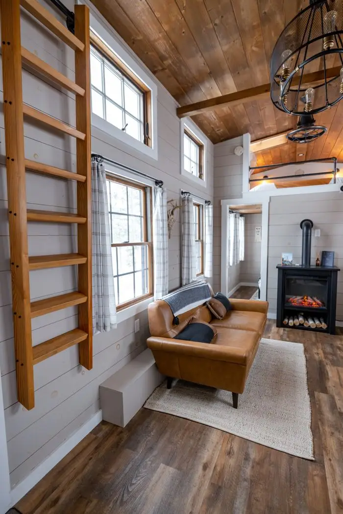 Warm and inviting rustic living room featuring a leather sofa and wood stove, ideal for relaxation. Shiplap Eagle